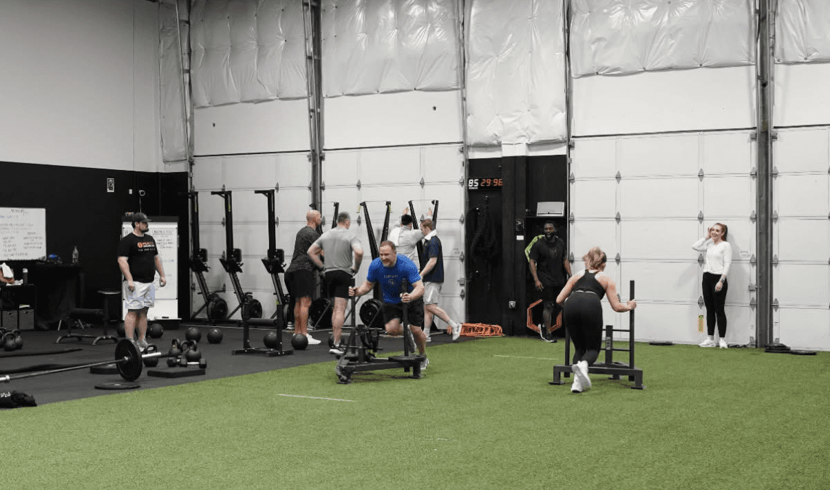Company team bonding sled relay during corporate wellness in Portland, Oregon