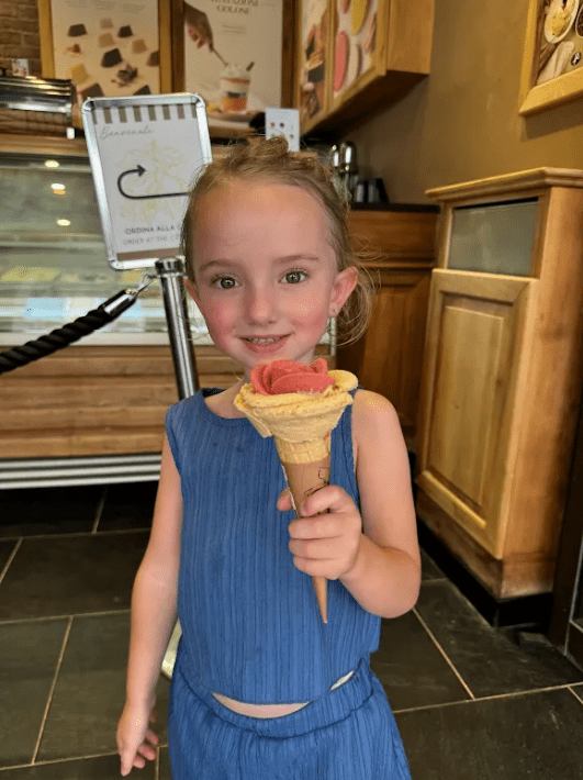 Thea, Jennie Carolan's daughter, holding a gelato cone at a gelateria in Italy during the family's month-long European trip
