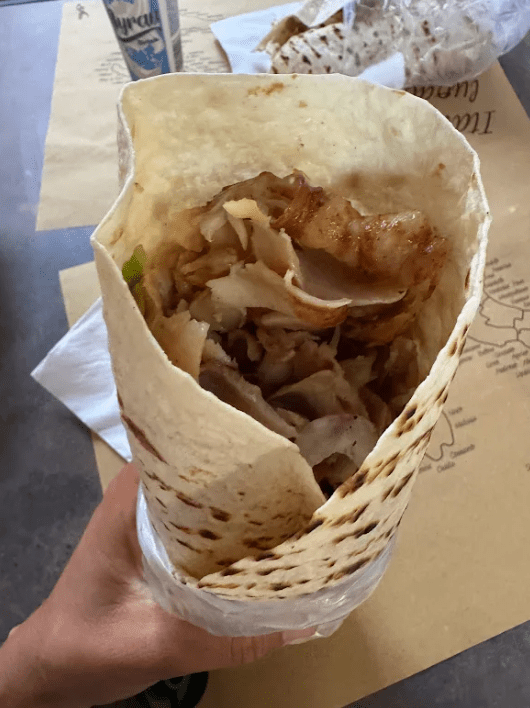 A chicken gyro wrap eaten during the family's Europe trip, an example of a protein-forward meal anchored in lean meat and vegetables